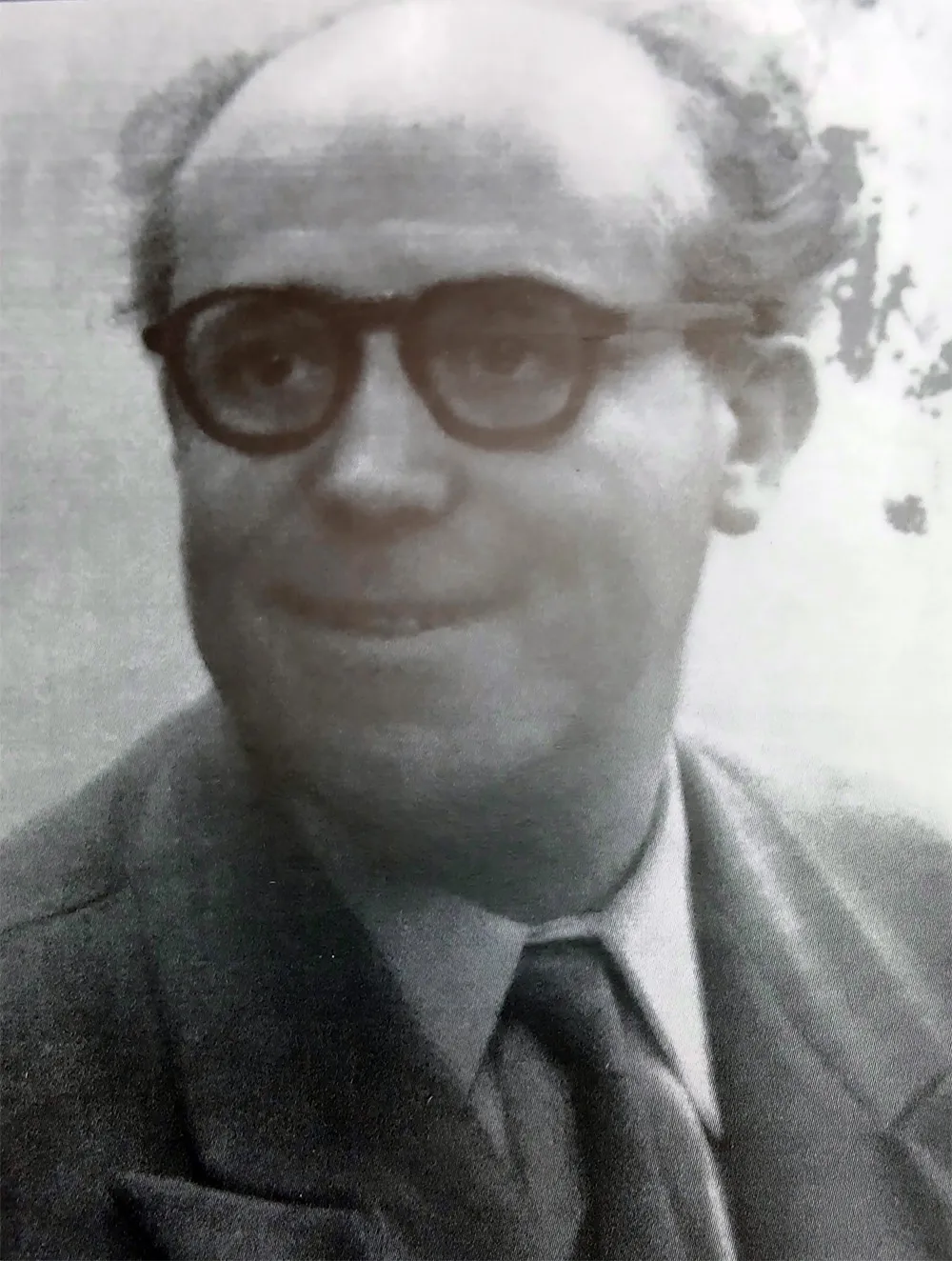 Photographie noir et blanc d'un homme d'une cinquantaine d'année à lunettes arrondies