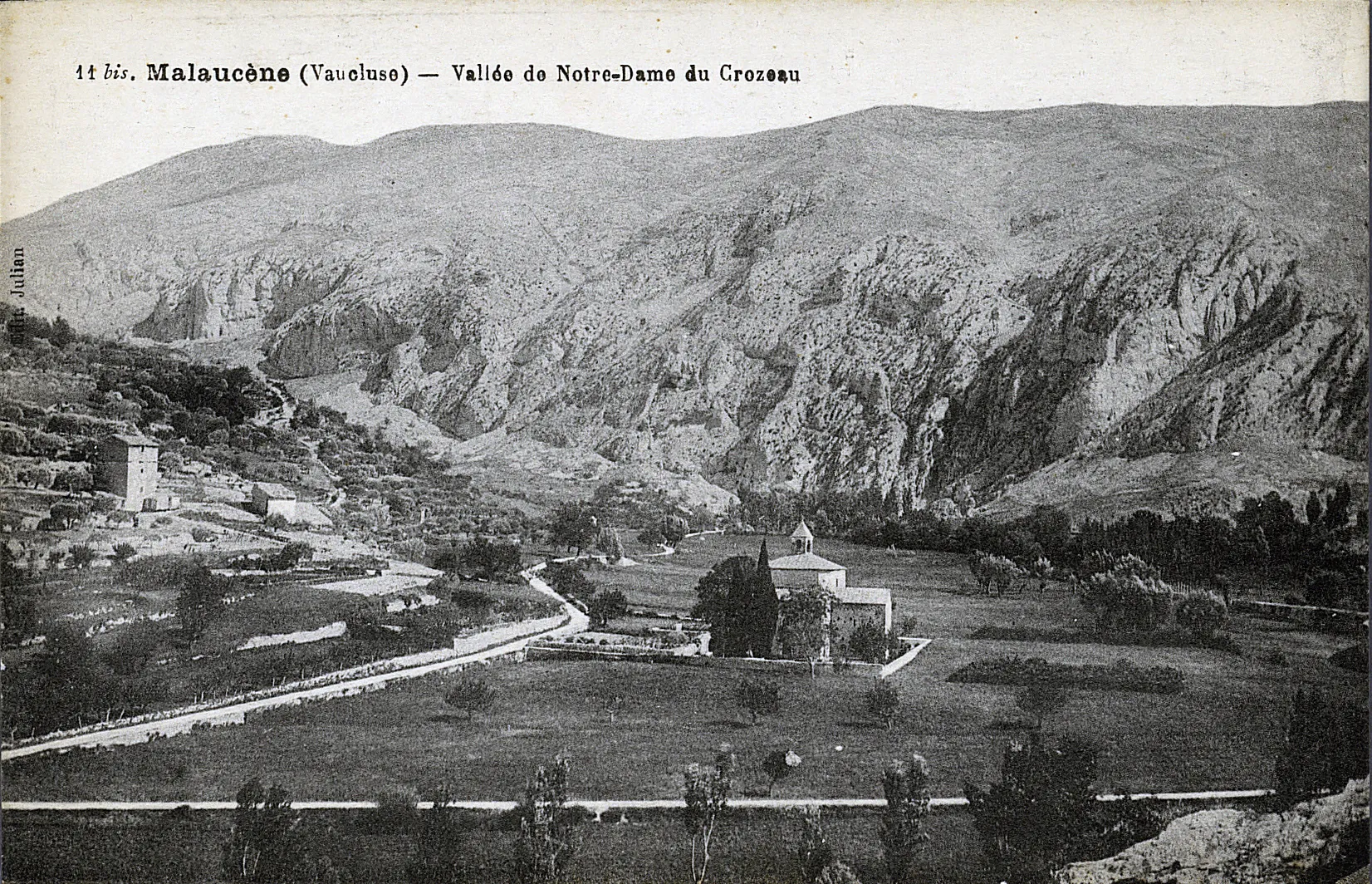 Photographie en noir et blanc montrant au centre la chapelle du Groseau, à gauche de l'image deux autres bâtiments et en fond, les contrforts du mont Ventoux
