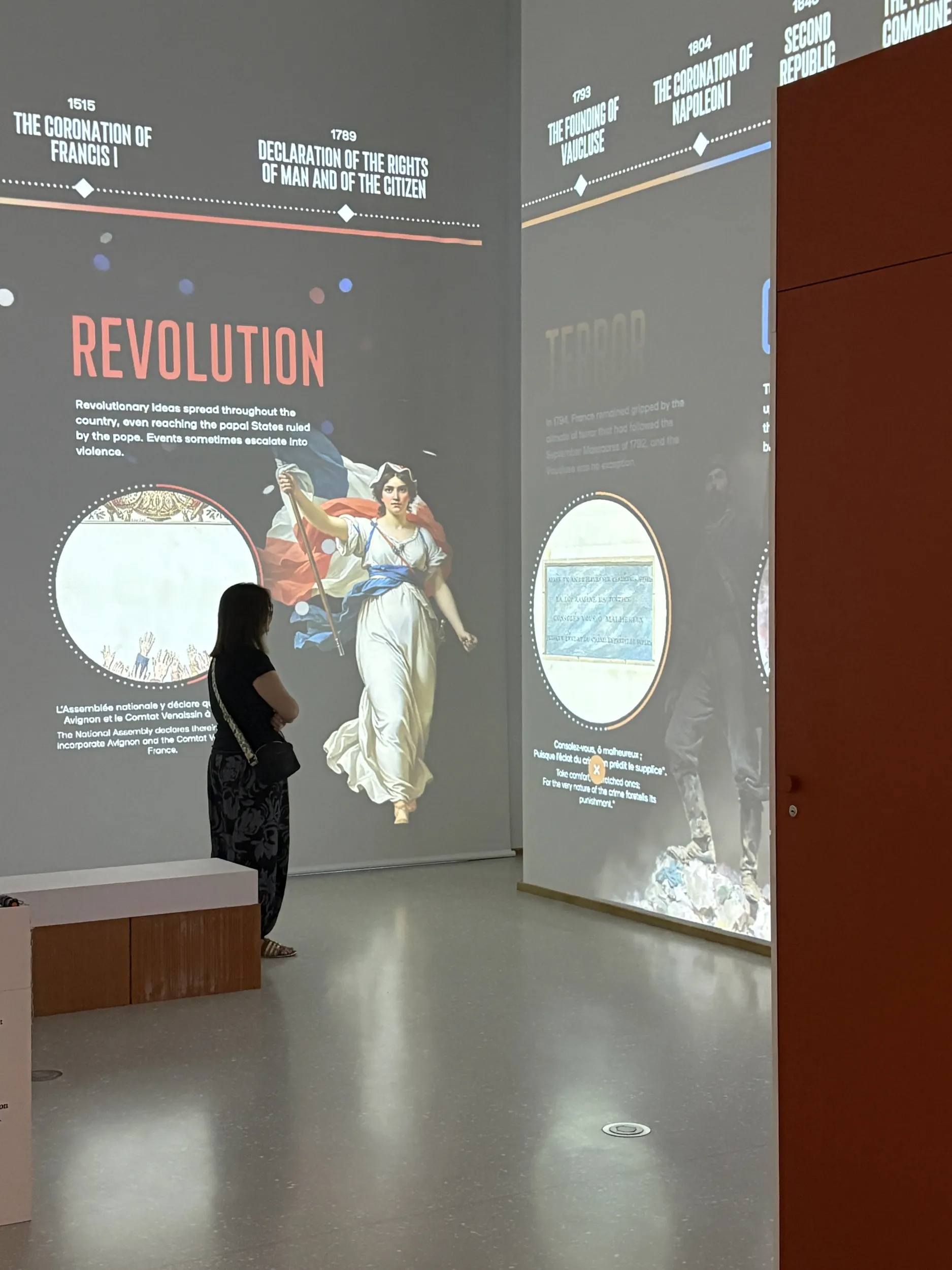 Plan d'ensemble sur une visiteuse devant la fresque interactive