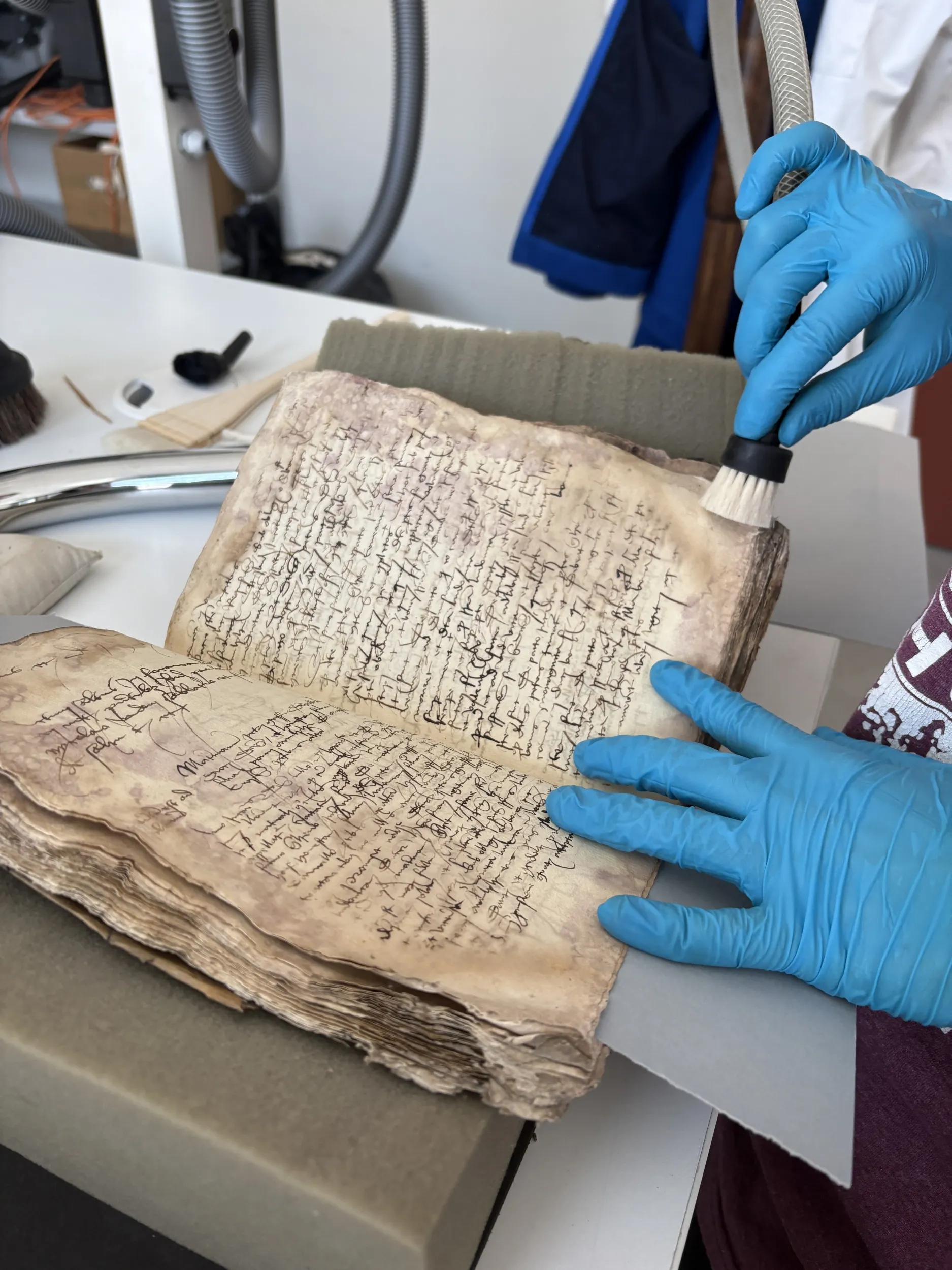 Un jeune homme aspire les poussières d'un livre ancien