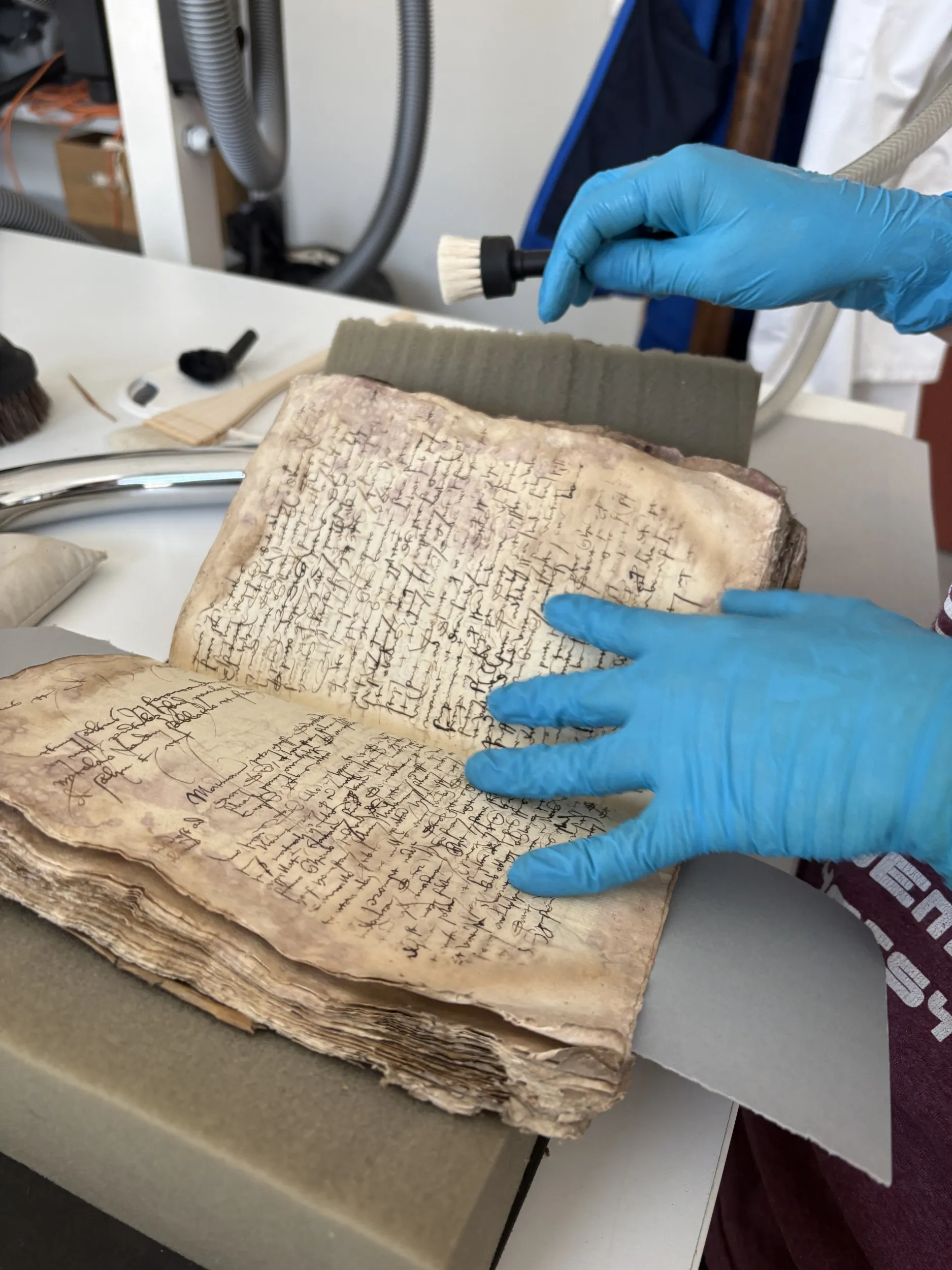 Un jeune homme aspire les poussières d'un livre ancien