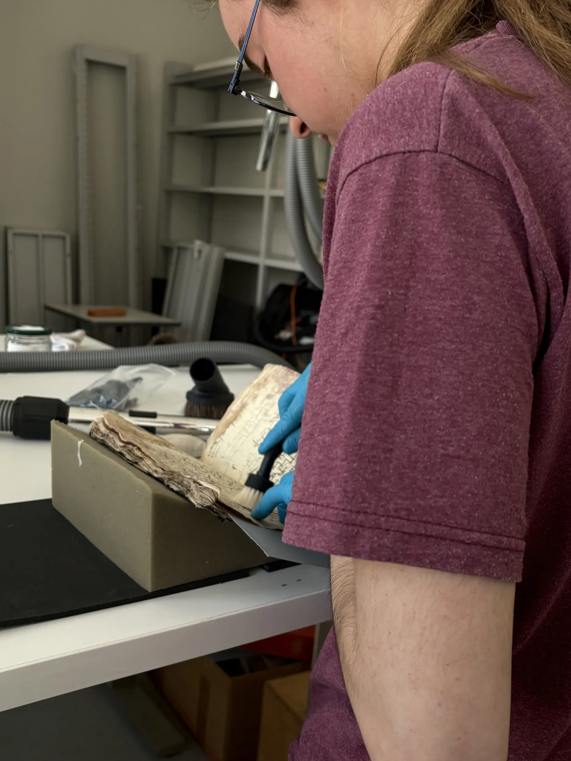 Un jeune homme aspire les poussières d'un livre ancien