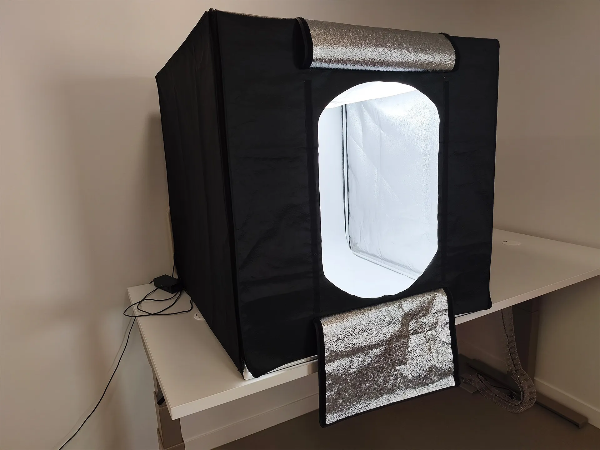 Boîte noire à l'extérieur, tapissée de blanc et éclairée à l'intérieur pour prise de vue des objets de collection