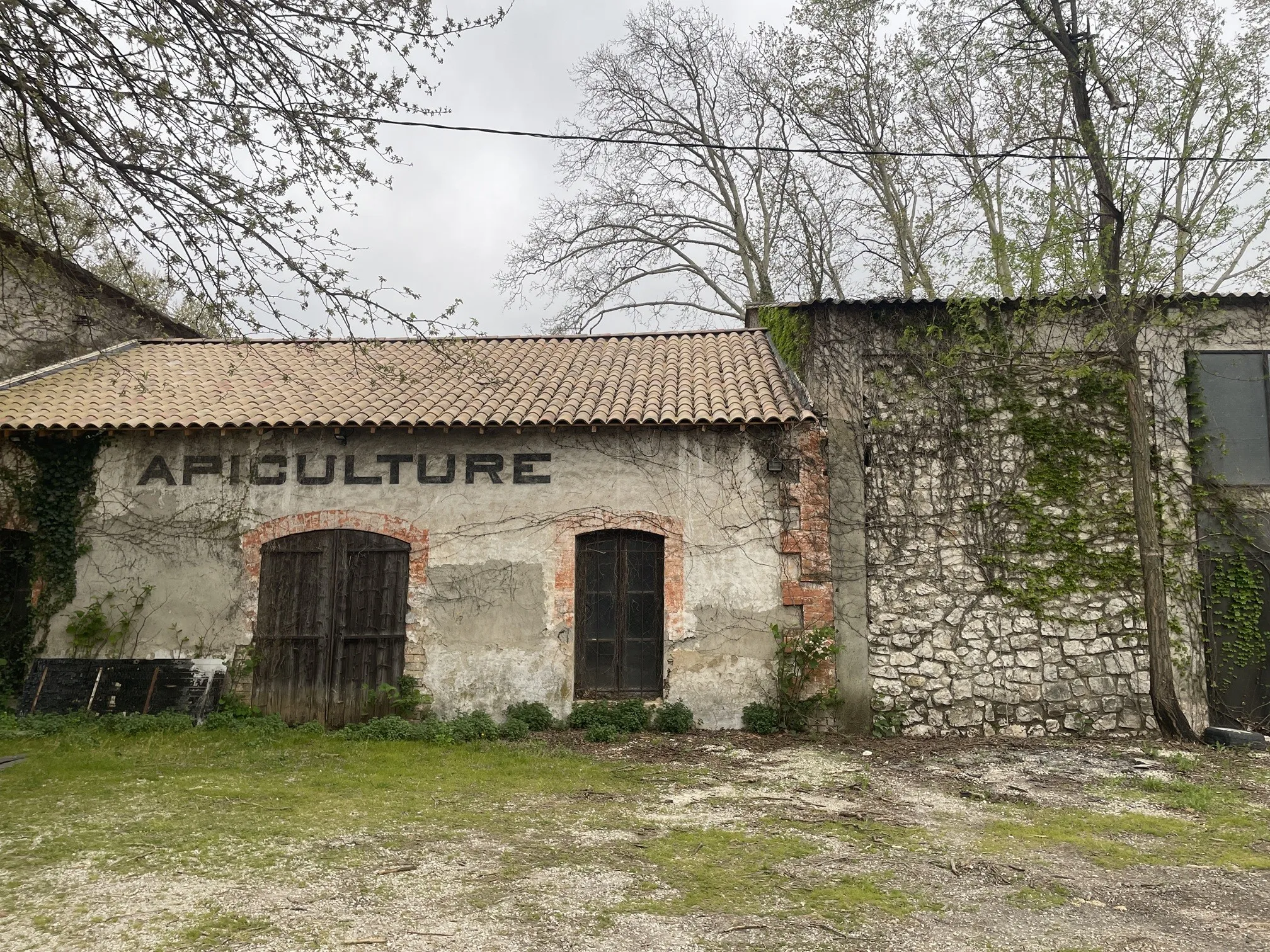 Bâtiment ancien et fermé sur lequel figure au dessus de la porte en grandes lettres majuscules "Apiculture"