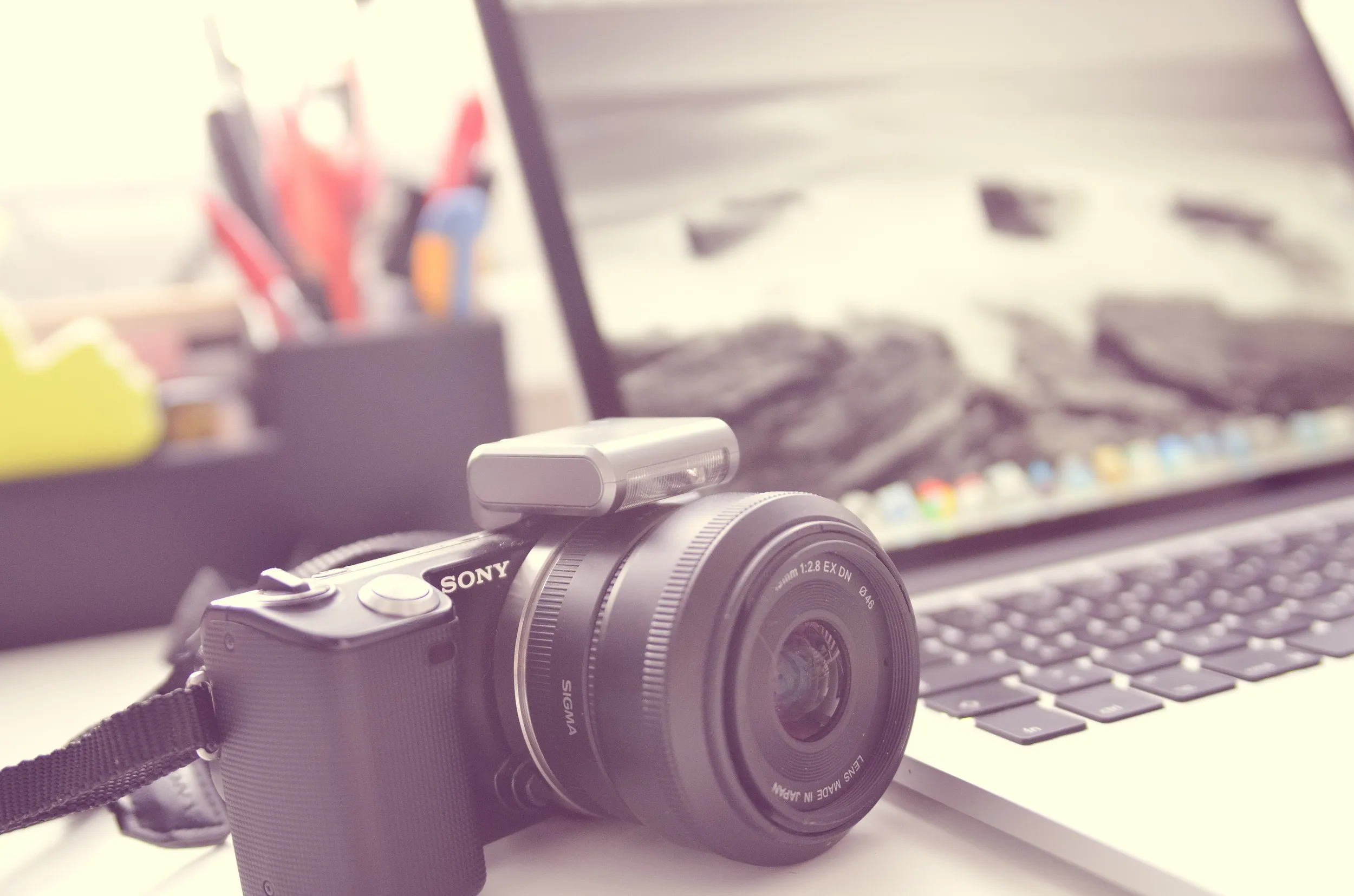Photo d'illustration d'un appareil photo numérique avec en fond un pc portable