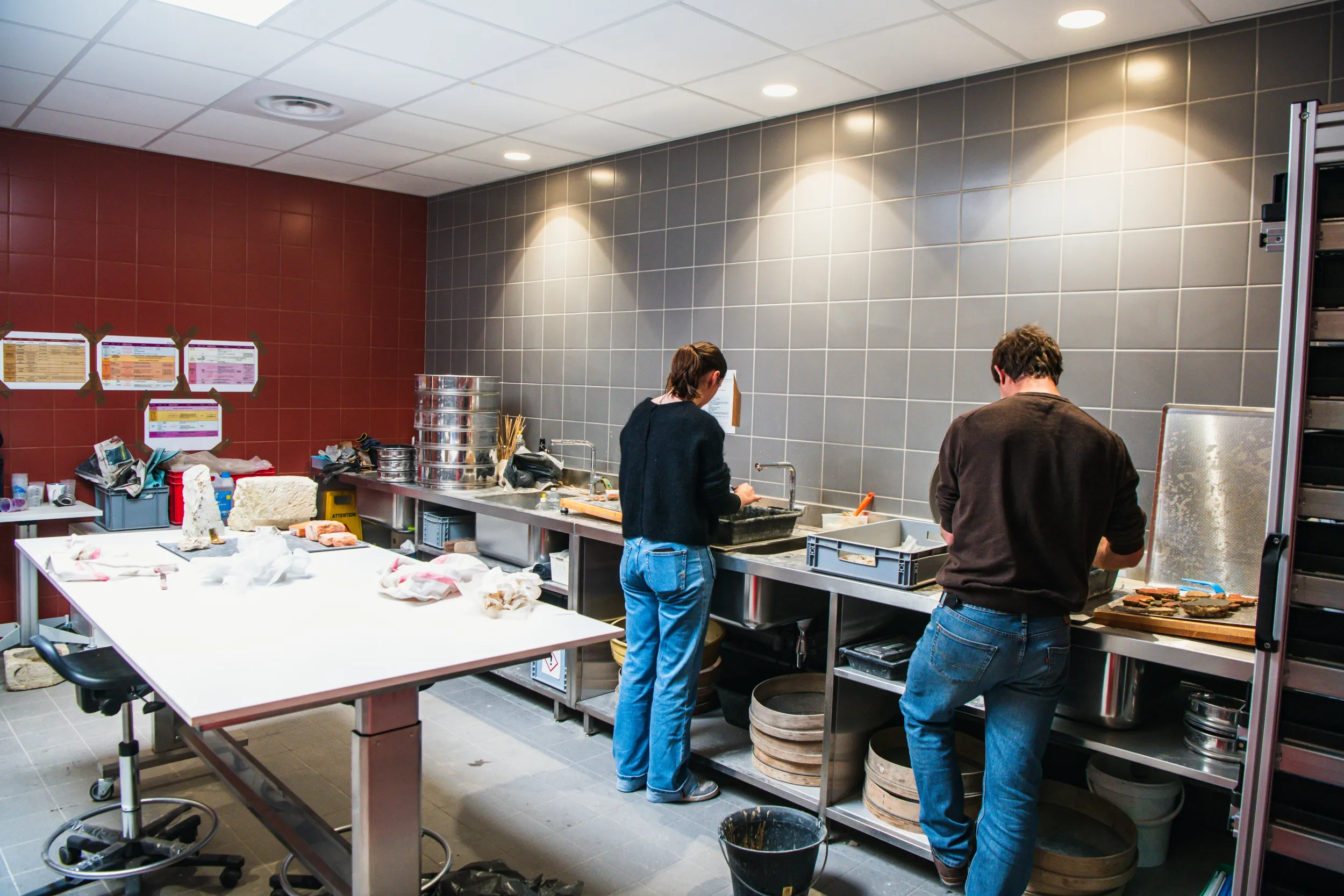 2 personnes dans la **salle de lavage** du service d'archéologie du Département de Vaucluse