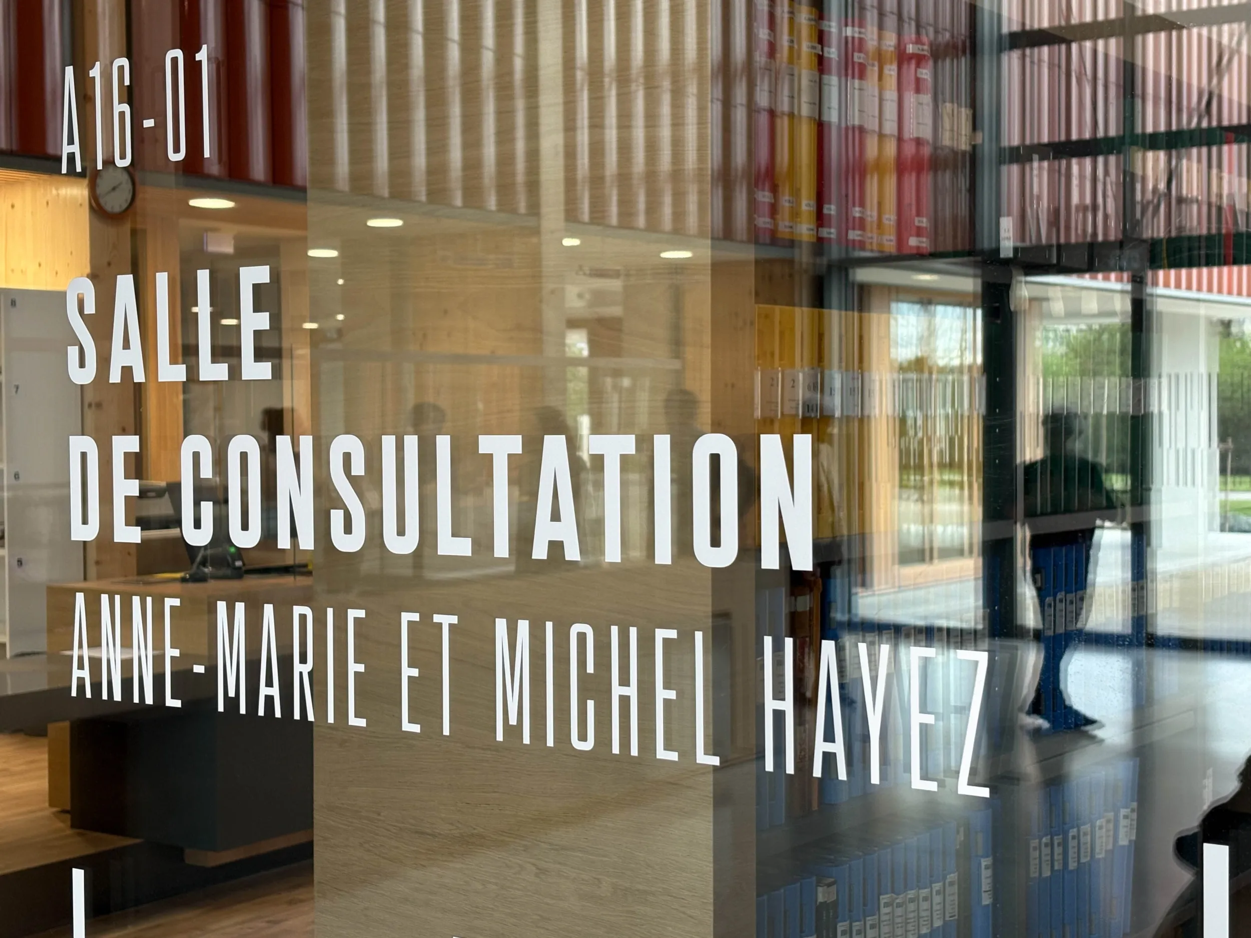 Baie vitrée portant la signalétique "Salle de consultation, Anne-Marie et Michel Hayez"