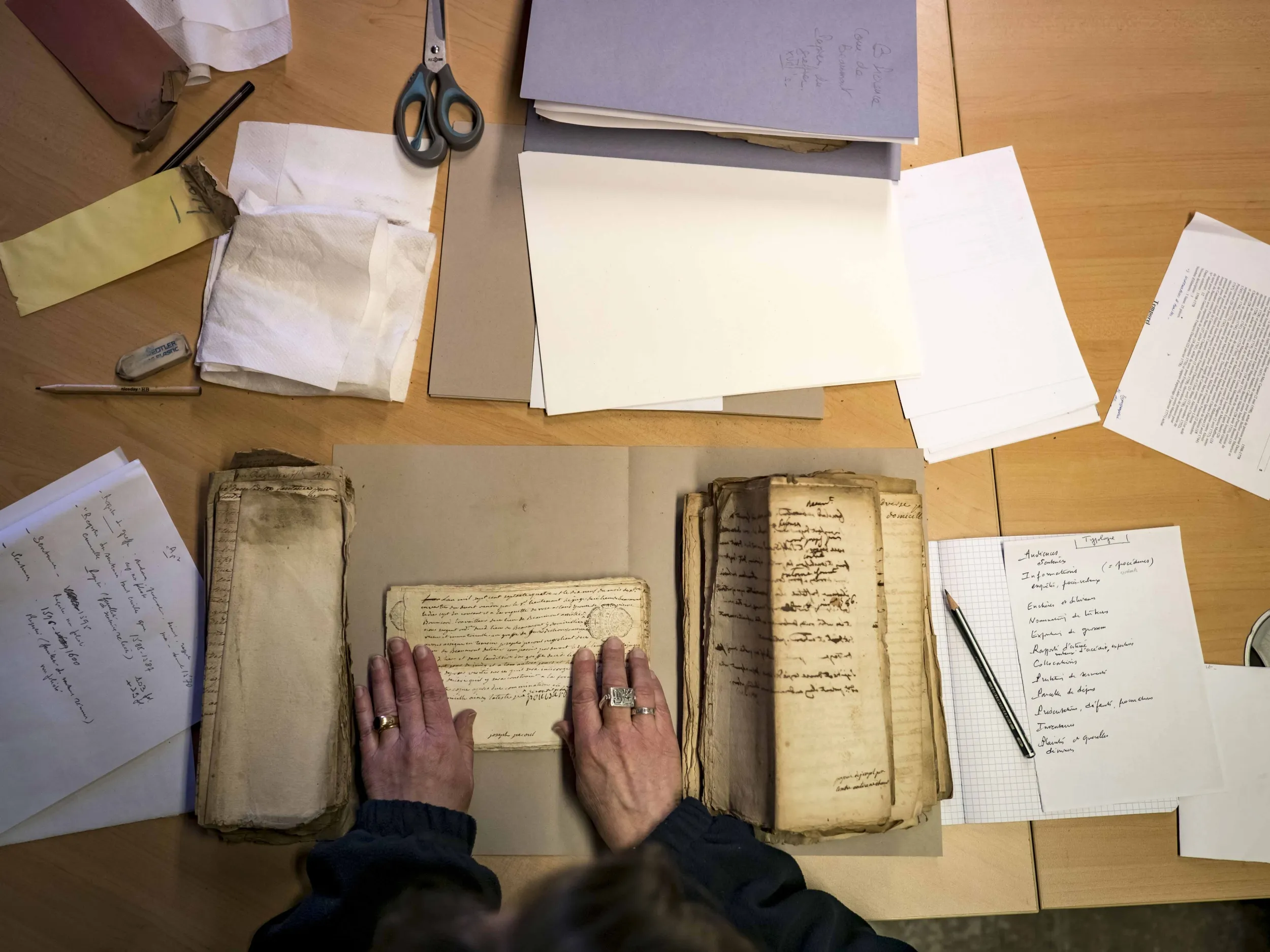 Vue sur des piles de documents et des mains de femme