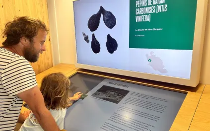 Un homme et une petite fille manipule une table écran