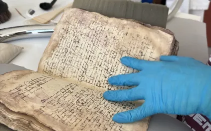 Un jeune homme aspire les poussières d'un livre ancien