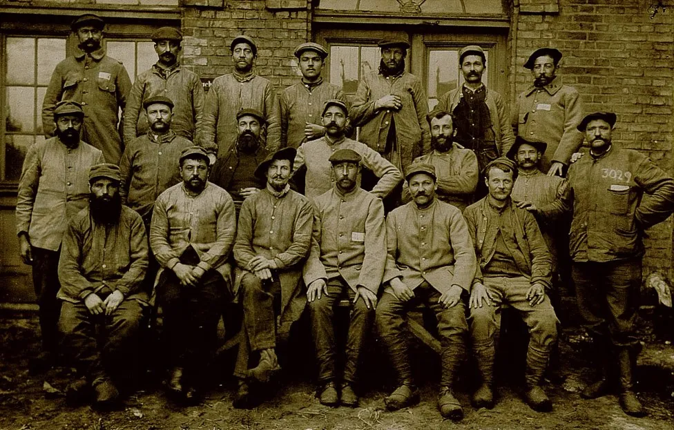 Photographie sépia montrant 20 soldats sur 3 rangées prenant la pose